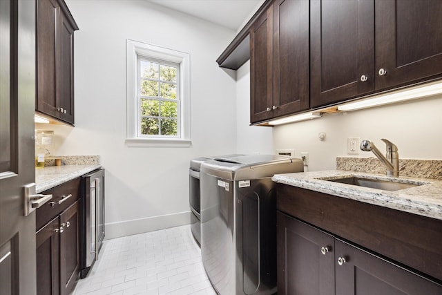 5420 Maple St, Bellaire, TX 77401 - laundry room featuring cabinet space, washing machine and dryer, baseboards, light tile patterned floors, and wine cooler