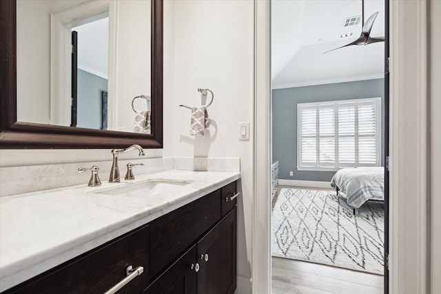 5420 Maple St, Bellaire, TX 77401 - bathroom featuring ornamental molding, vanity, wood finished floors, baseboards, and ensuite bathroom