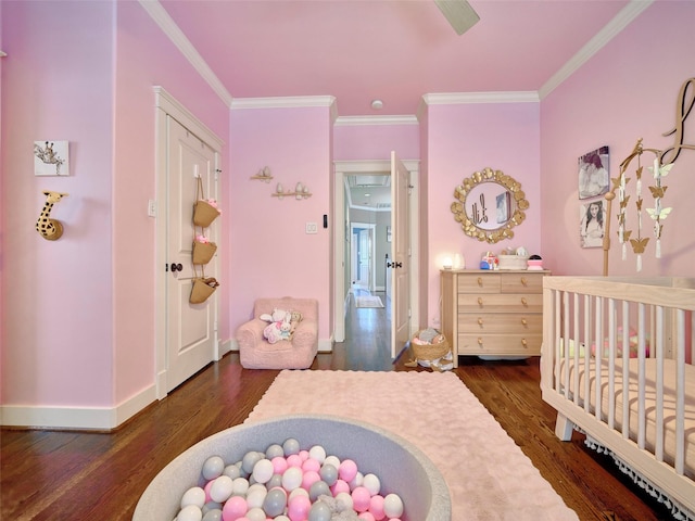 228 E Woodland St, Houston, TX 77009 - bedroom featuring ornamental molding, wood finished floors, a crib, and baseboards