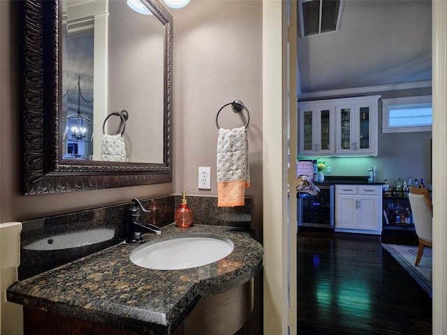 228 E Woodland St, Houston, TX 77009 - bathroom with wood finished floors, vanity, and wine cooler