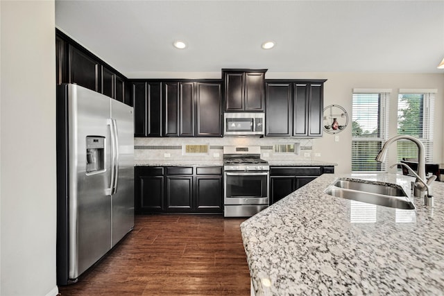 2635 Cedar Path Ln, Conroe, TX 77385 - kitchen with stainless steel appliances, a sink, backsplash, light stone countertops, and recessed lighting