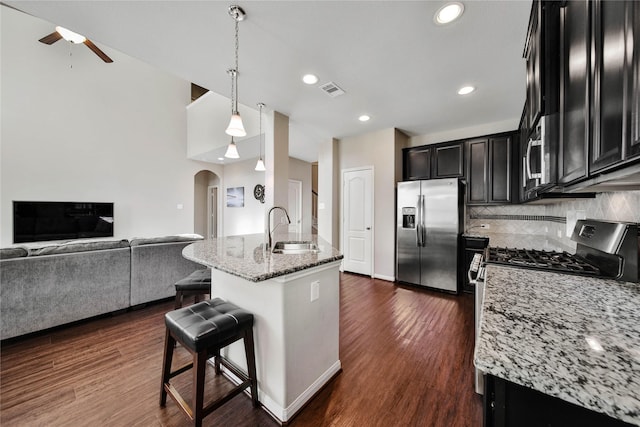 2635 Cedar Path Ln, Conroe, TX 77385 - kitchen with appliances with stainless steel finishes, a sink, a ceiling fan, open floor plan, and arched walkways
