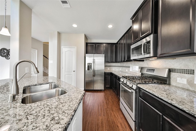 2635 Cedar Path Ln, Conroe, TX 77385 - kitchen with appliances with stainless steel finishes, a sink, dark wood finished floors, light stone counters, and recessed lighting