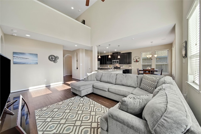 2635 Cedar Path Ln, Conroe, TX 77385 - living area with arched walkways, wood finished floors, plenty of natural light, a chandelier, and a towering ceiling