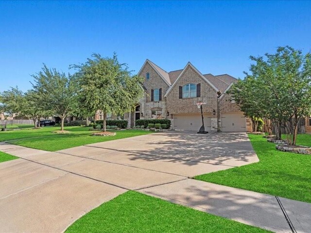 20326 Scarlett Saddle Ct, Cypress, TX 77433 - view of front of property featuring driveway, a garage, a front yard, and stone siding