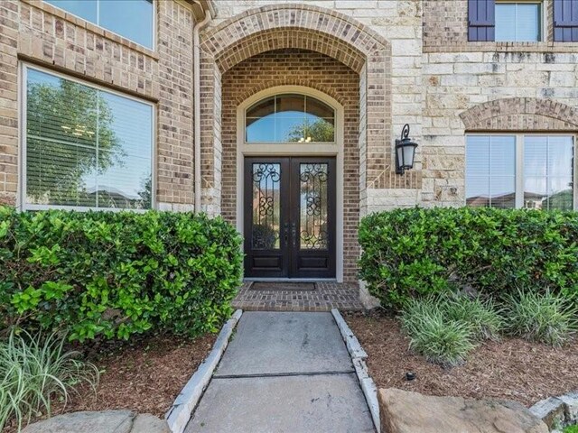 20326 Scarlett Saddle Ct, Cypress, TX 77433 - entrance to property featuring french doors, brick siding, and stone siding