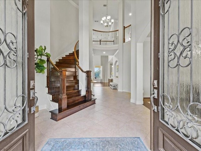 20326 Scarlett Saddle Ct, Cypress, TX 77433 - foyer featuring a towering ceiling, a chandelier, stairway, baseboards, and light tile patterned floors
