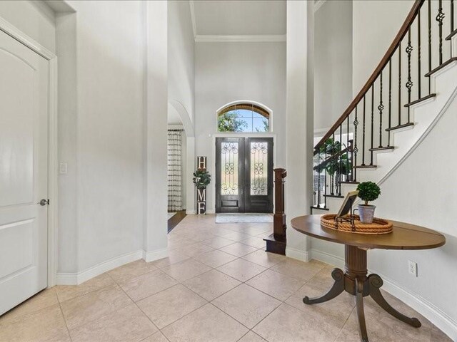20326 Scarlett Saddle Ct, Cypress, TX 77433 - foyer entrance featuring a towering ceiling, stairs, crown molding, arched walkways, and light tile patterned flooring