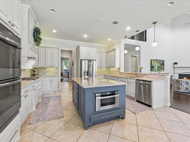 20326 Scarlett Saddle Ct, Cypress, TX 77433 - kitchen featuring stainless steel appliances, a sink, backsplash, pendant lighting, and ornamental molding