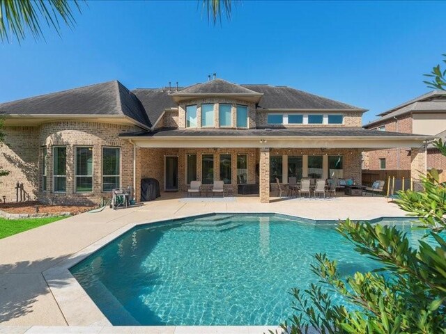 20326 Scarlett Saddle Ct, Cypress, TX 77433 - rear view of house featuring a patio area, an outdoor pool, and brick siding