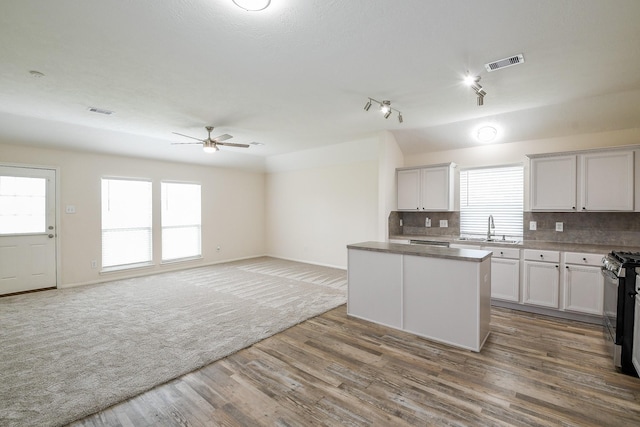 9203 Windy Spring Ct, Houston, TX 77089 - kitchen featuring a ceiling fan, tasteful backsplash, stainless steel gas range, a center island, and a sink