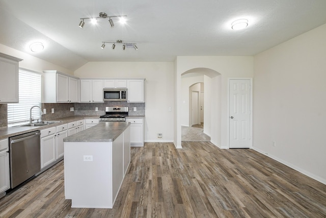 9203 Windy Spring Ct, Houston, TX 77089 - kitchen featuring stainless steel appliances, a sink, arched walkways, lofted ceiling, and backsplash