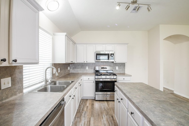 9203 Windy Spring Ct, Houston, TX 77089 - kitchen with stainless steel appliances, a sink, white cabinetry, light countertops, and vaulted ceiling