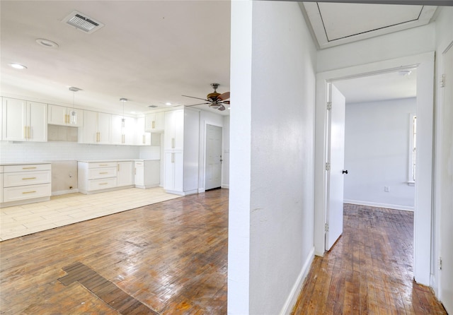 7314 Yoe St, Houston, TX 77016 - kitchen featuring light wood-style floors, white cabinets, a ceiling fan, hanging light fixtures, and recessed lighting