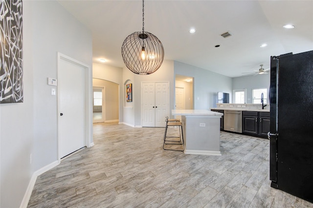 21811 Blossom Grove Ln, Spring, TX 77379 - kitchen featuring freestanding refrigerator, stainless steel dishwasher, ceiling fan, light countertops, and arched walkways