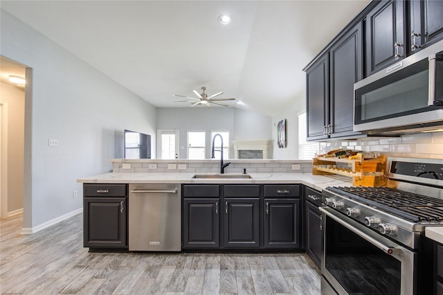 21811 Blossom Grove Ln, Spring, TX 77379 - kitchen featuring stainless steel appliances, a sink, backsplash, a ceiling fan, and vaulted ceiling