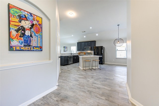 21811 Blossom Grove Ln, Spring, TX 77379 - kitchen with stainless steel appliances, light countertops, a sink, baseboards, and a breakfast bar