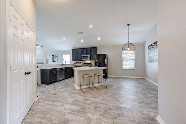 21811 Blossom Grove Ln, Spring, TX 77379 - kitchen featuring stainless steel appliances, light countertops, a kitchen island, baseboards, and a breakfast bar