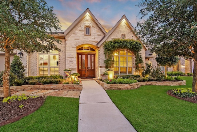 7118 Kinglet Ct, Katy, TX 77493 - french country home with a front lawn, stone siding, and french doors