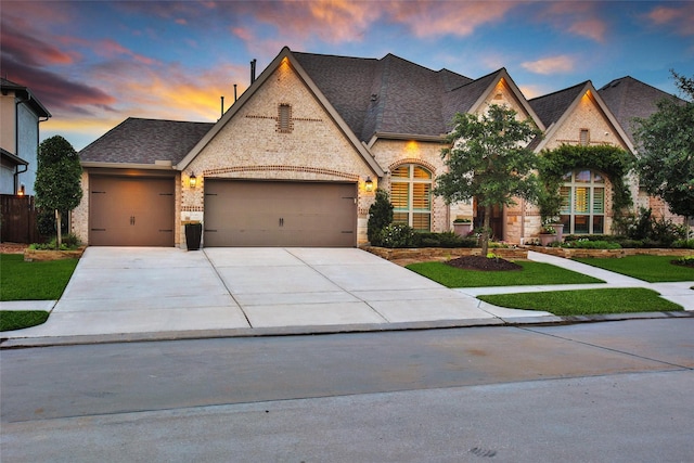 7118 Kinglet Ct, Katy, TX 77493 - french country style house with a garage, concrete driveway, brick siding, and roof with shingles