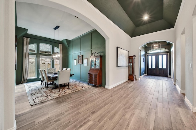 7118 Kinglet Ct, Katy, TX 77493 - dining space featuring a chandelier, wood finished floors, baseboards, lofted ceiling, and arched walkways
