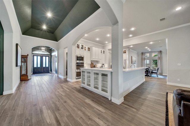 7118 Kinglet Ct, Katy, TX 77493 - foyer with healthy amount of natural light, arched walkways, light wood-style flooring, ornamental molding, and french doors