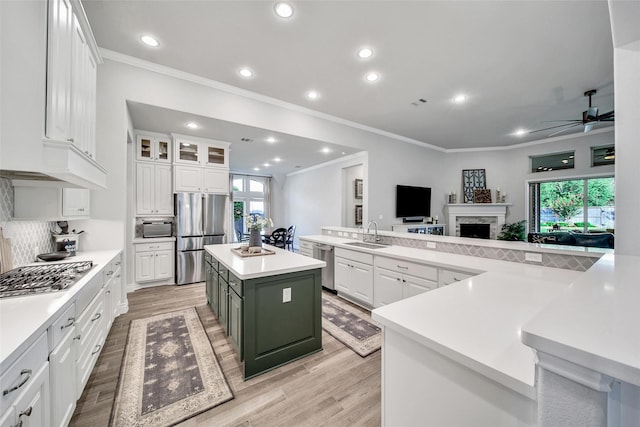 7118 Kinglet Ct, Katy, TX 77493 - kitchen with appliances with stainless steel finishes, a large island, a sink, ornamental molding, and a ceiling fan