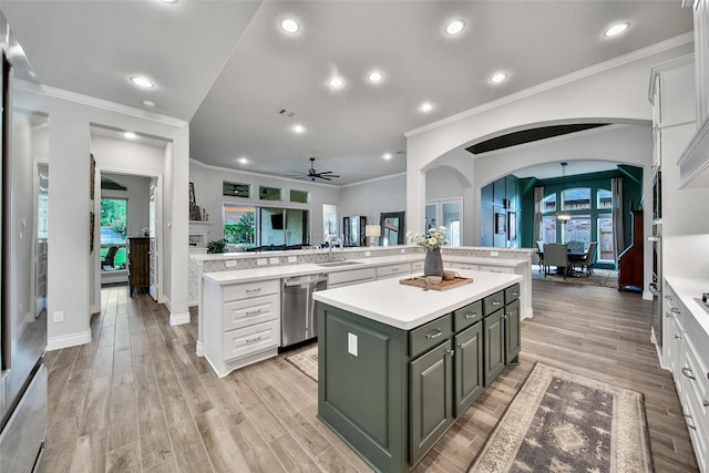 7118 Kinglet Ct, Katy, TX 77493 - kitchen with stainless steel dishwasher, a center island, ceiling fan, light countertops, and white cabinetry