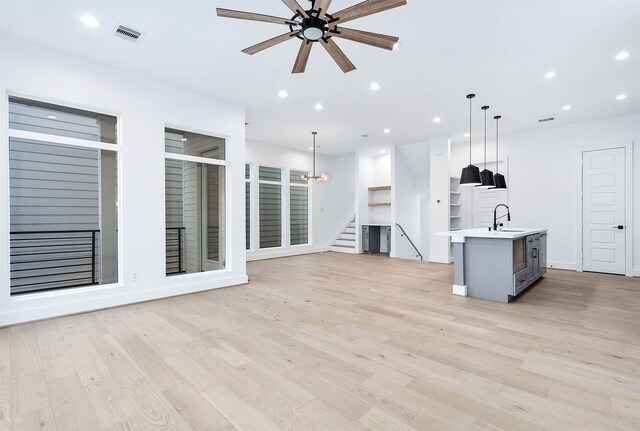 1707 Milby St, Houston, TX 77003 - unfurnished living room featuring a ceiling fan, light wood-style flooring, recessed lighting, stairs, and a sink