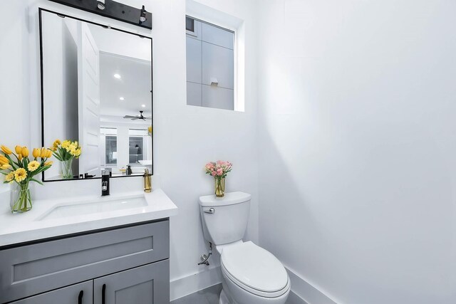 1707 Milby St, Houston, TX 77003 - half bathroom with toilet, vanity, baseboards, and ceiling fan