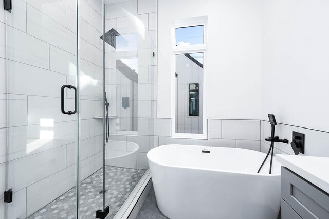 1707 Milby St, Houston, TX 77003 - full bathroom with tile walls, a freestanding tub, vanity, and a shower stall