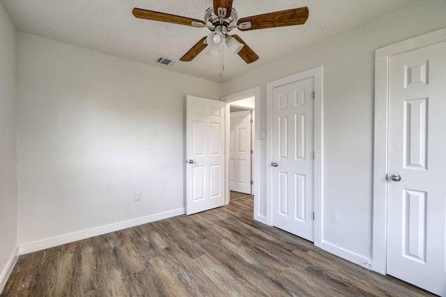 7437 Navasota St, Houston, TX 77016 - unfurnished bedroom with dark wood-style flooring, baseboards, and a ceiling fan