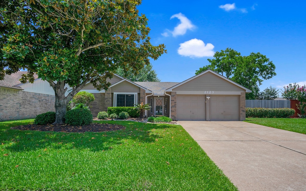 2123 Fountain Dr, Sugar Land, TX 77478 - ranch-style house with brick siding, an attached garage, and driveway