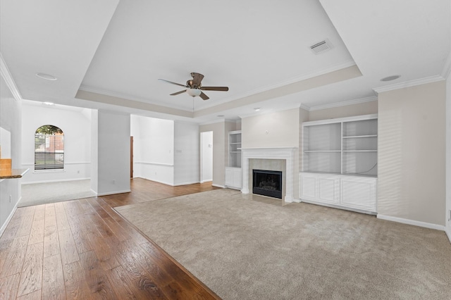6119 Plantation Bay Dr, Katy, TX 77449 - unfurnished living room featuring a tray ceiling, ornamental molding, baseboards, ceiling fan, and hardwood / wood-style floors