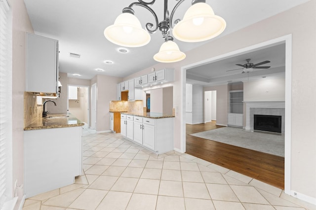 6119 Plantation Bay Dr, Katy, TX 77449 - kitchen with a sink, light tile patterned floors, dark stone countertops, and decorative backsplash