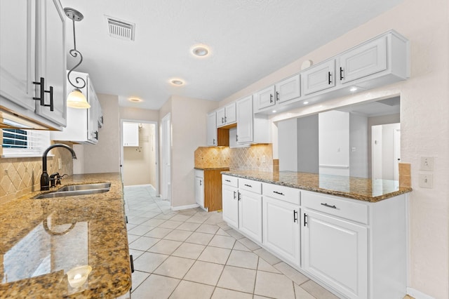 6119 Plantation Bay Dr, Katy, TX 77449 - kitchen featuring a sink, backsplash, baseboards, white cabinets, and recessed lighting