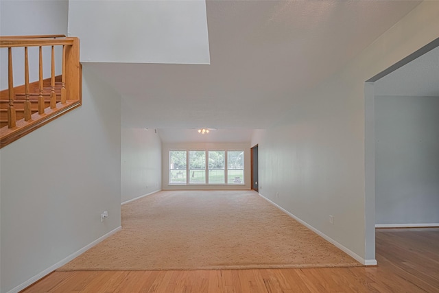 144 Pin Oak Ln, Hempstead, TX 77445 - unfurnished living room with wood finished floors, baseboards, stairs, and carpet