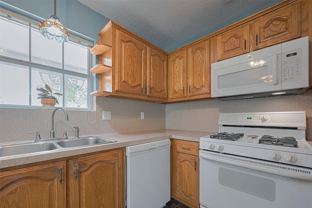 144 Pin Oak Ln, Hempstead, TX 77445 - kitchen with white appliances, a sink, light countertops, brown cabinets, and a textured ceiling