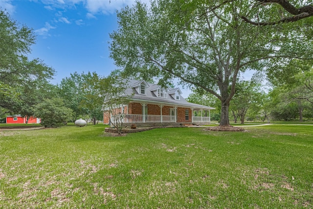 144 Pin Oak Ln, Hempstead, TX 77445 - view of front of home with brick siding, covered porch, and a front yard