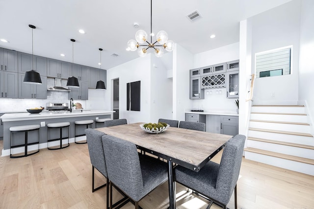 3808 Jefferson St, Houston, TX 77003 - dining space featuring light wood-style floors, a chandelier, stairs, recessed lighting, and bar area