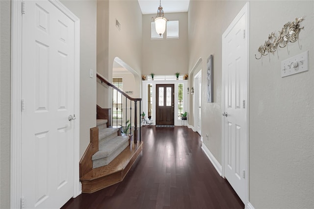 3730 Arundel Gardens Ln, Sugar Land, TX 77498 - foyer entrance featuring a towering ceiling, dark wood finished floors, baseboards, stairway, and arched walkways