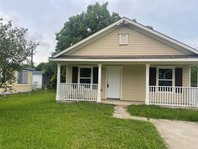 2430 Florence St, La Marque, TX 77568 - bungalow with a porch, a front lawn, and a shingled roof