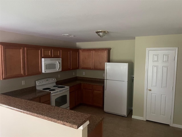 2430 Florence St, La Marque, TX 77568 - kitchen with white appliances, dark countertops, brown cabinets, and a peninsula