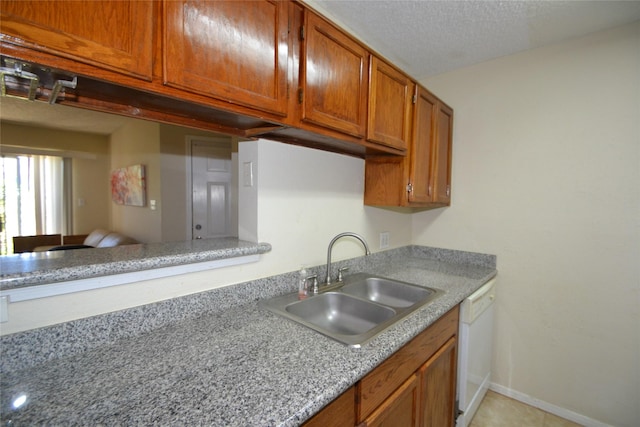 2121 Hepburn Sts Unit 713, Houston, TX 77054 - kitchen with a sink, dishwasher, brown cabinetry, light countertops, and a textured ceiling