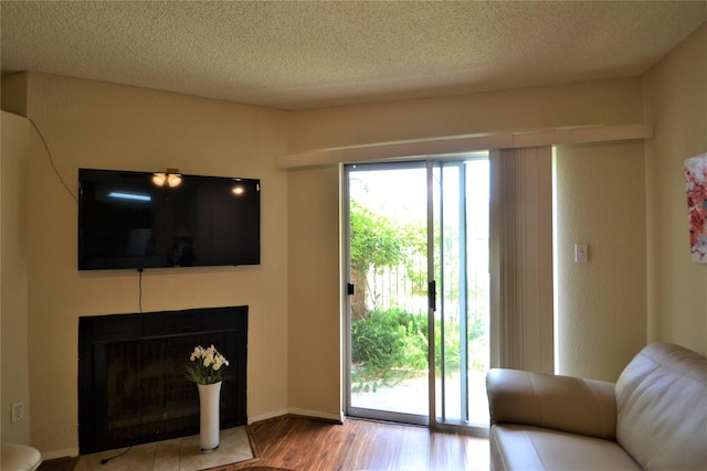 2121 Hepburn Sts Unit 713, Houston, TX 77054 - living area with wood finished floors, a textured ceiling, and a fireplace with flush hearth