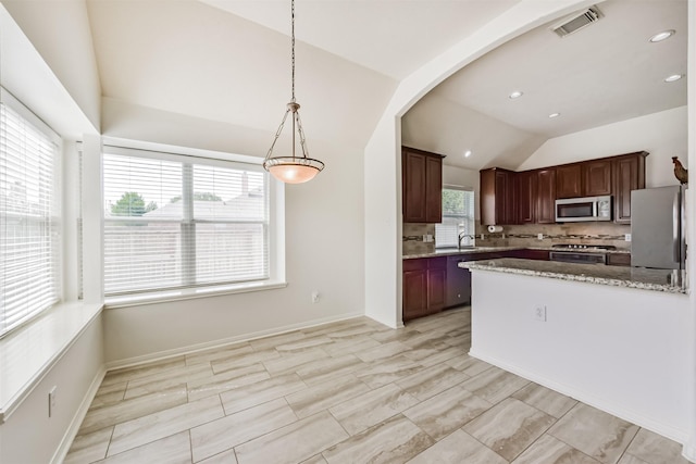 7518 Rain Meadow Ln, Cypress, TX 77433 - kitchen with stainless steel microwave, stove, vaulted ceiling, a sink, and decorative backsplash