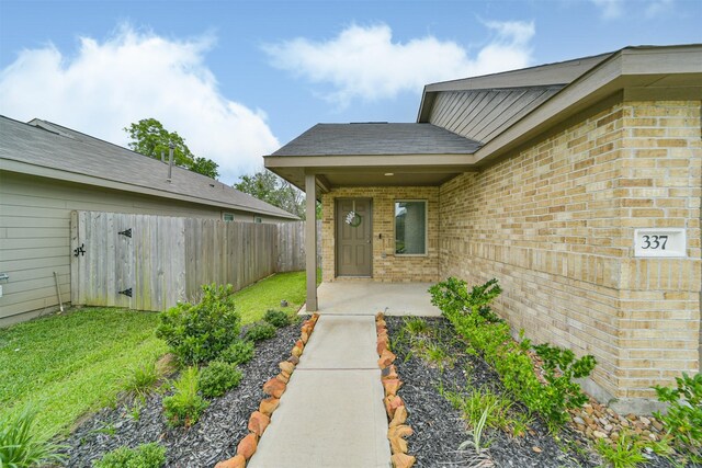 337 Riverwood Village Ln, Sealy, TX 77474 - view of exterior entry featuring brick siding and a patio area
