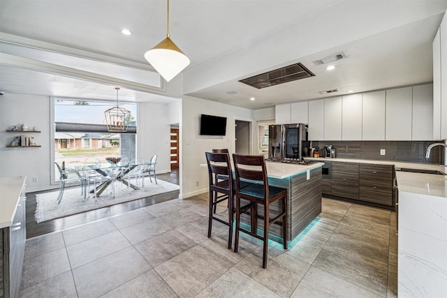 5231 Lamonte Ln, Houston, TX 77092 - kitchen featuring fridge with ice dispenser, modern cabinets, light countertops, decorative backsplash, and a sink