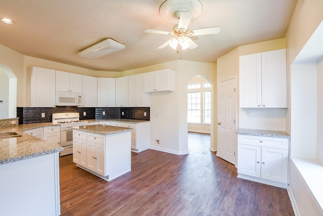 3550 Beacons Vw, Friendswood, TX 77546 - kitchen featuring arched walkways, white appliances, light stone counters, and recessed lighting