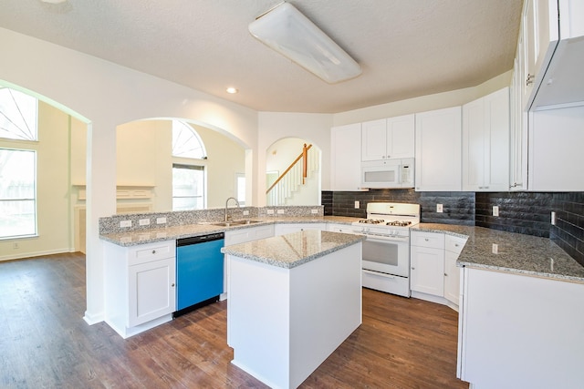 3550 Beacons Vw, Friendswood, TX 77546 - kitchen with white appliances, a sink, arched walkways, white cabinets, and recessed lighting